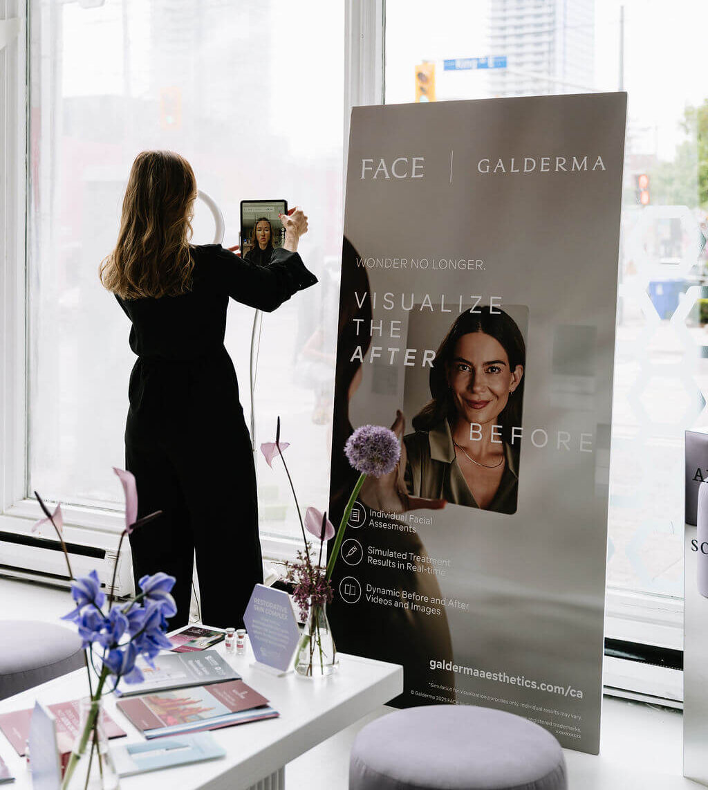 Pilar Adams A woman takes a photo with a tablet near a large Galderma skincare promotional display in a bright, modern room with large windows. Communications & Event Strategist