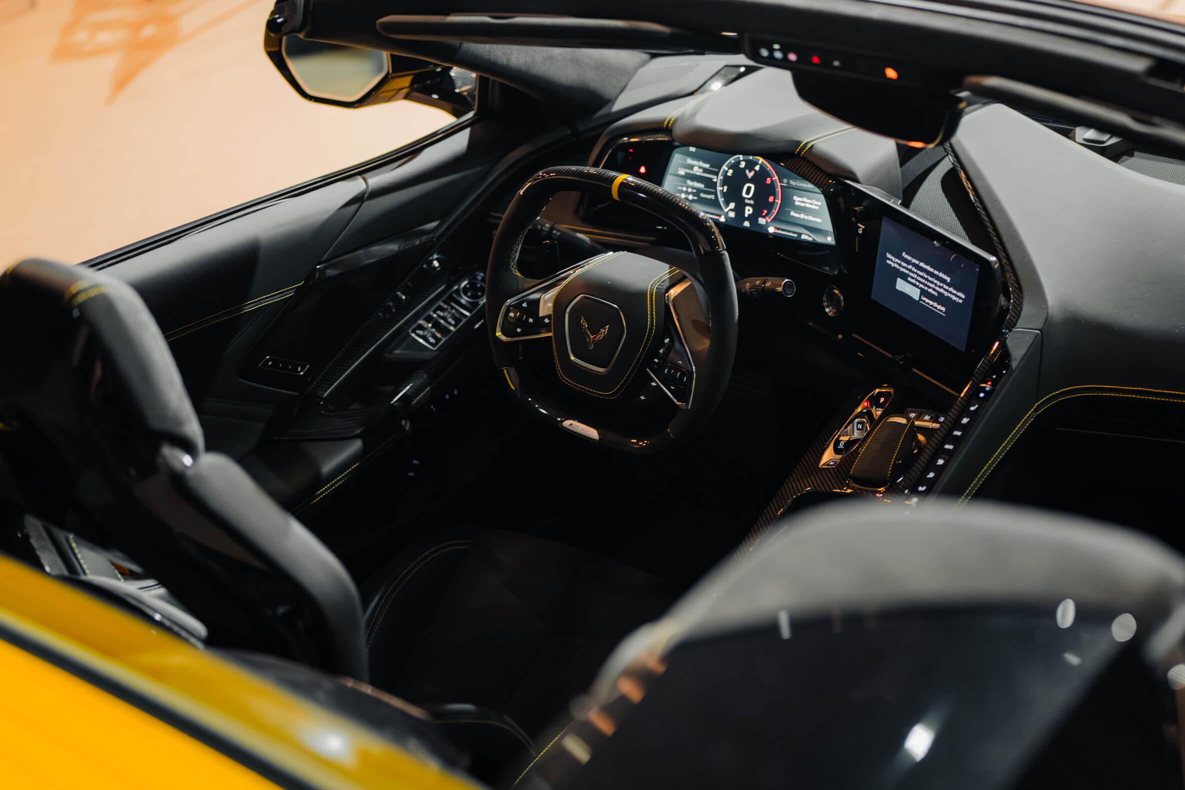 Pilar Adams Interior view of a modern sports car showing a digital dashboard, steering wheel with logo, center console controls, and leather seats. Communications & Event Strategist